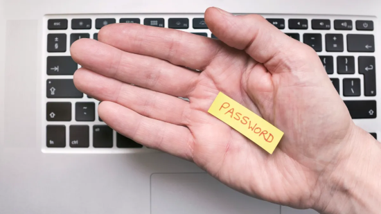 Hand holding a paper with "password."