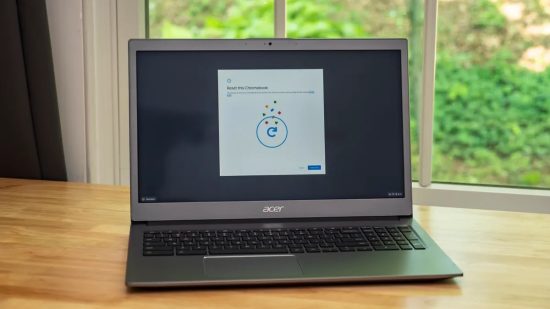 Acer Chromebook displaying a reset screen on a wooden table near a window.